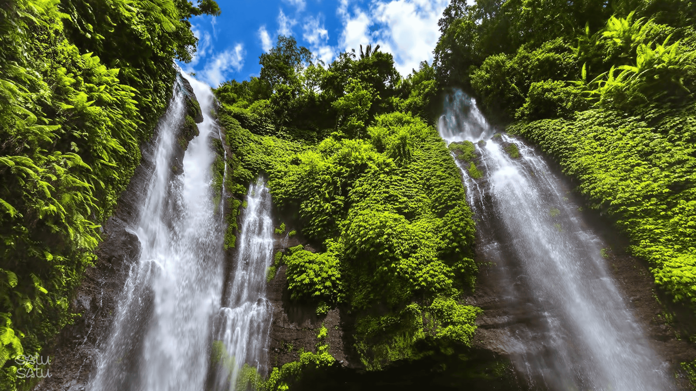 Twin waterfalls surrounded by lush tropical forest at Sekumpul Waterfall in Bali.
