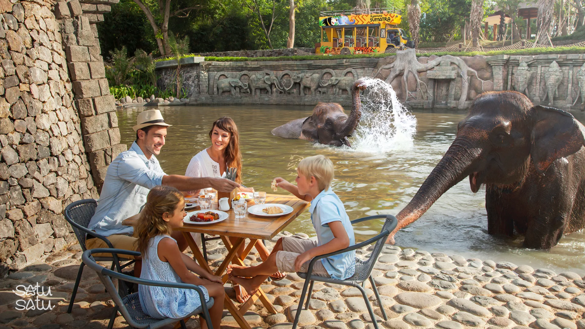 Family enjoying breakfast near elephants at Bali Zoo, a unique wildlife dining experience in Bali.