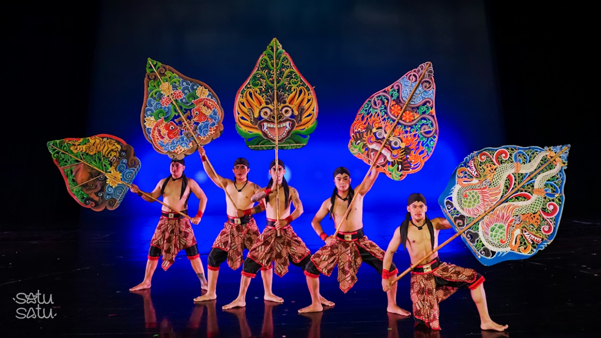 Male performers holding giant wayang props during Devdan Show cultural performance in Bali